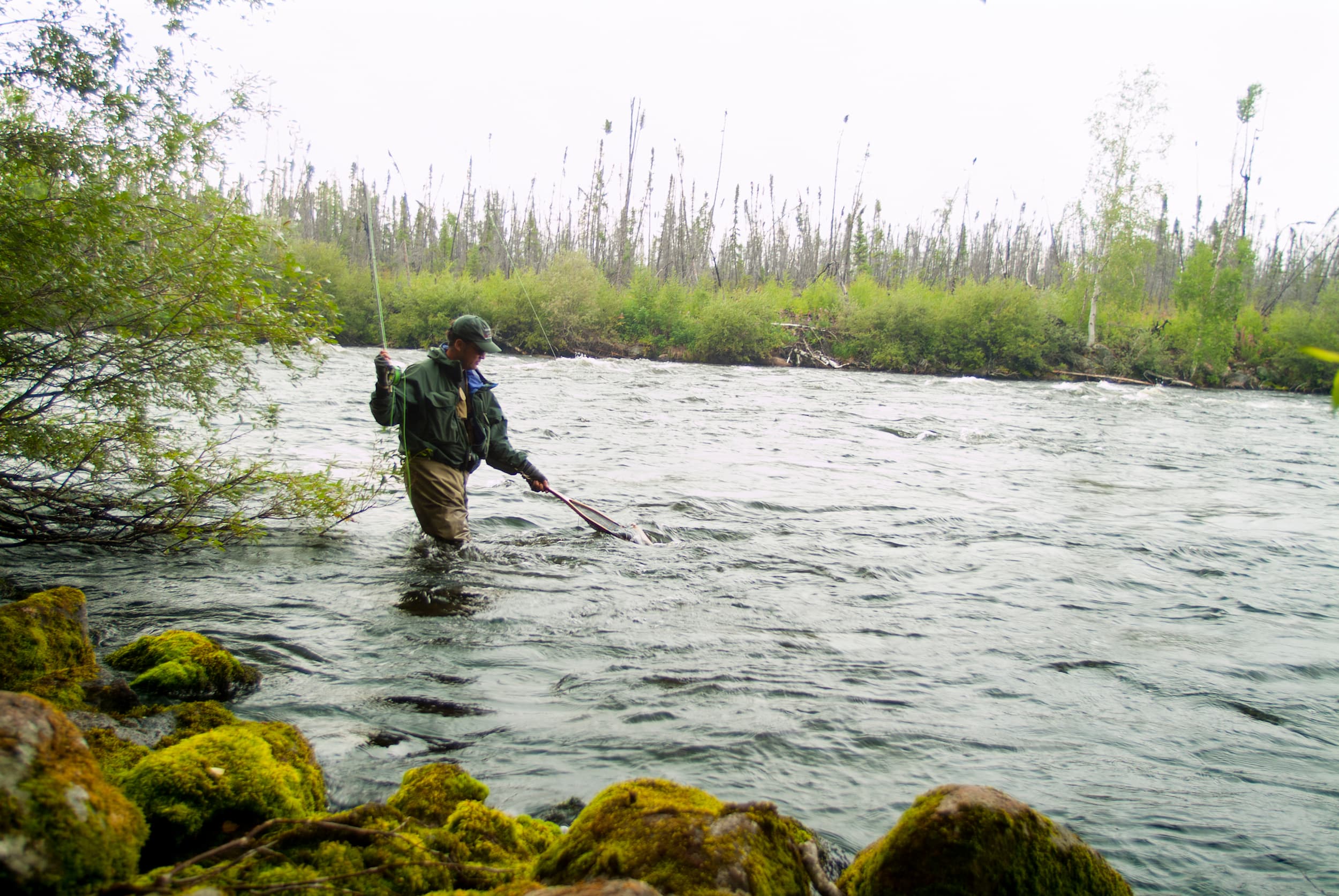 person standing in the water fly fishing