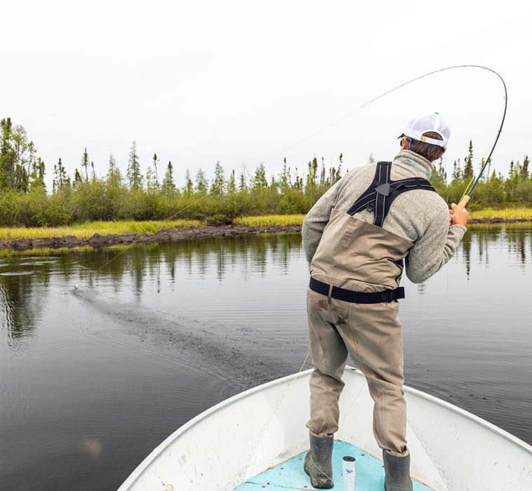 person fishing on a boat and their fishing rod is bent