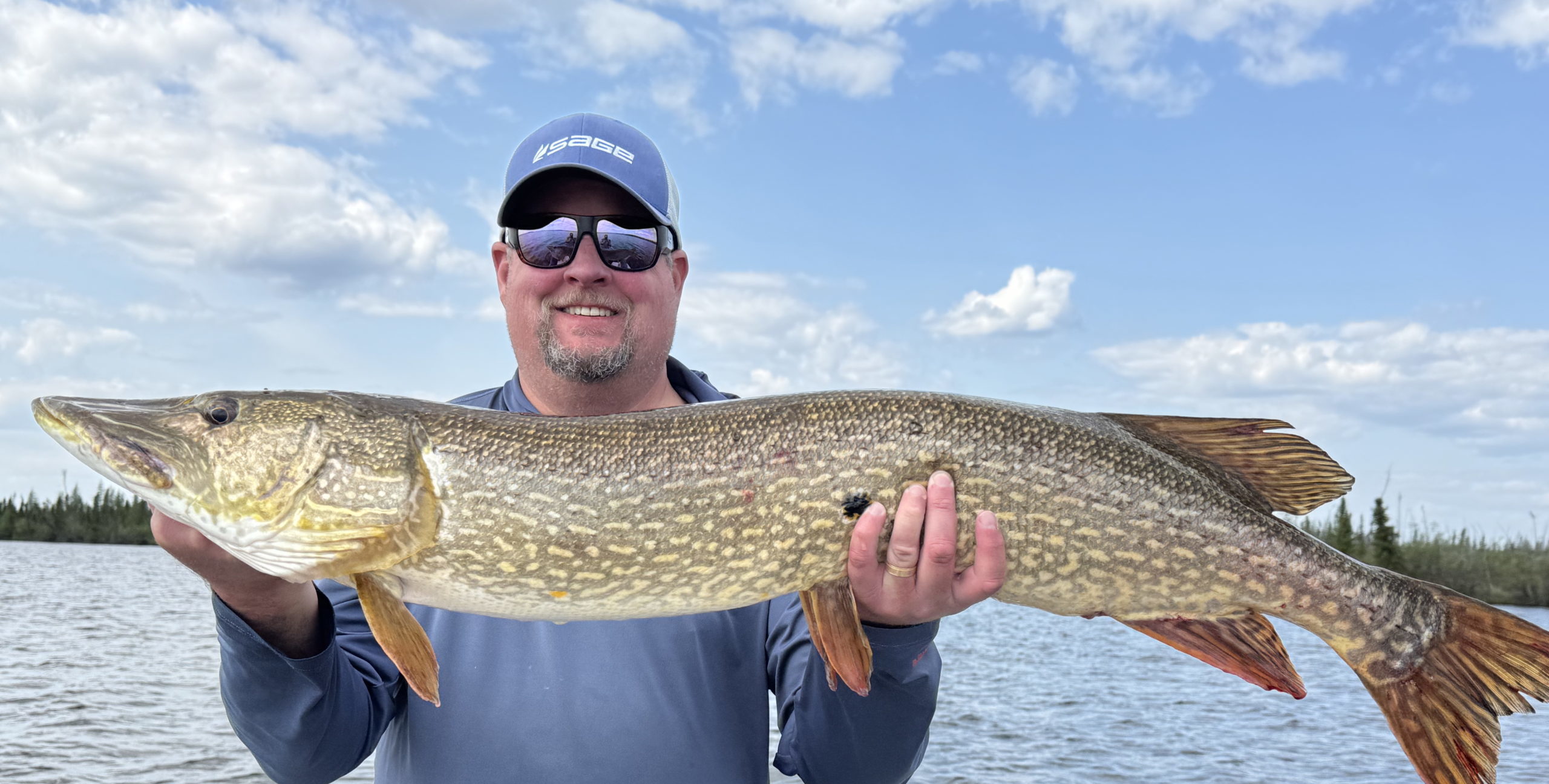 Image of Matt Simmons holding a large fish while standing in a boat.